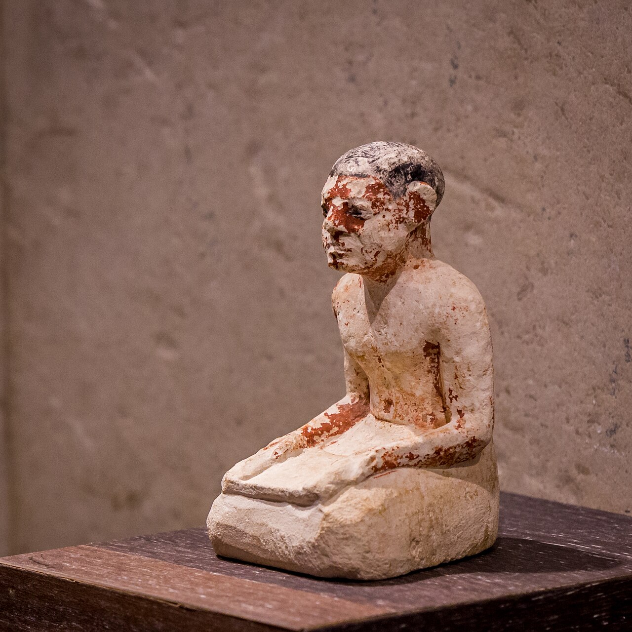 Portrait 
        statuette of an 
        Egyptian scribe sitting on the floor