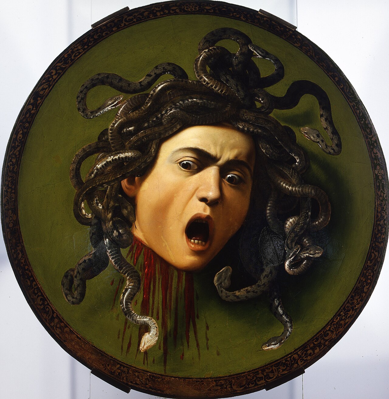 Caravaggio's painted Medusa head with serpents for hair, shown on the complete circular shield.