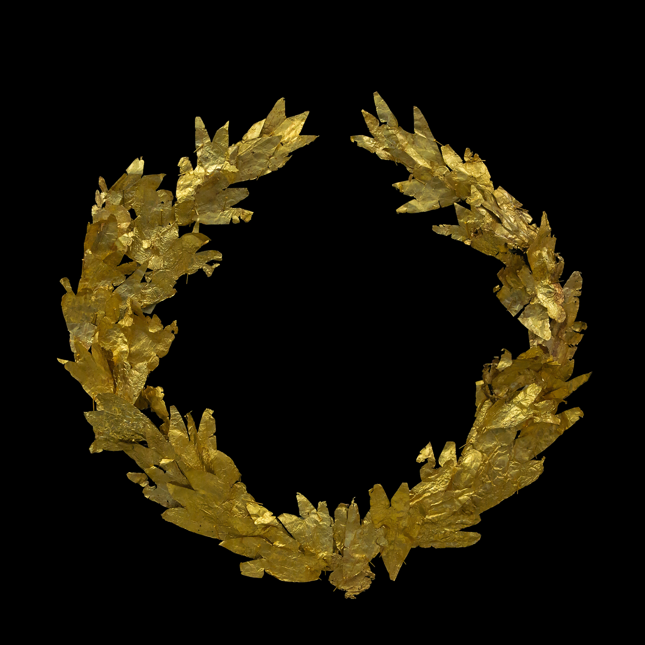 An entire golden laurel wreath with dense overlapping leaves, shown against a black background