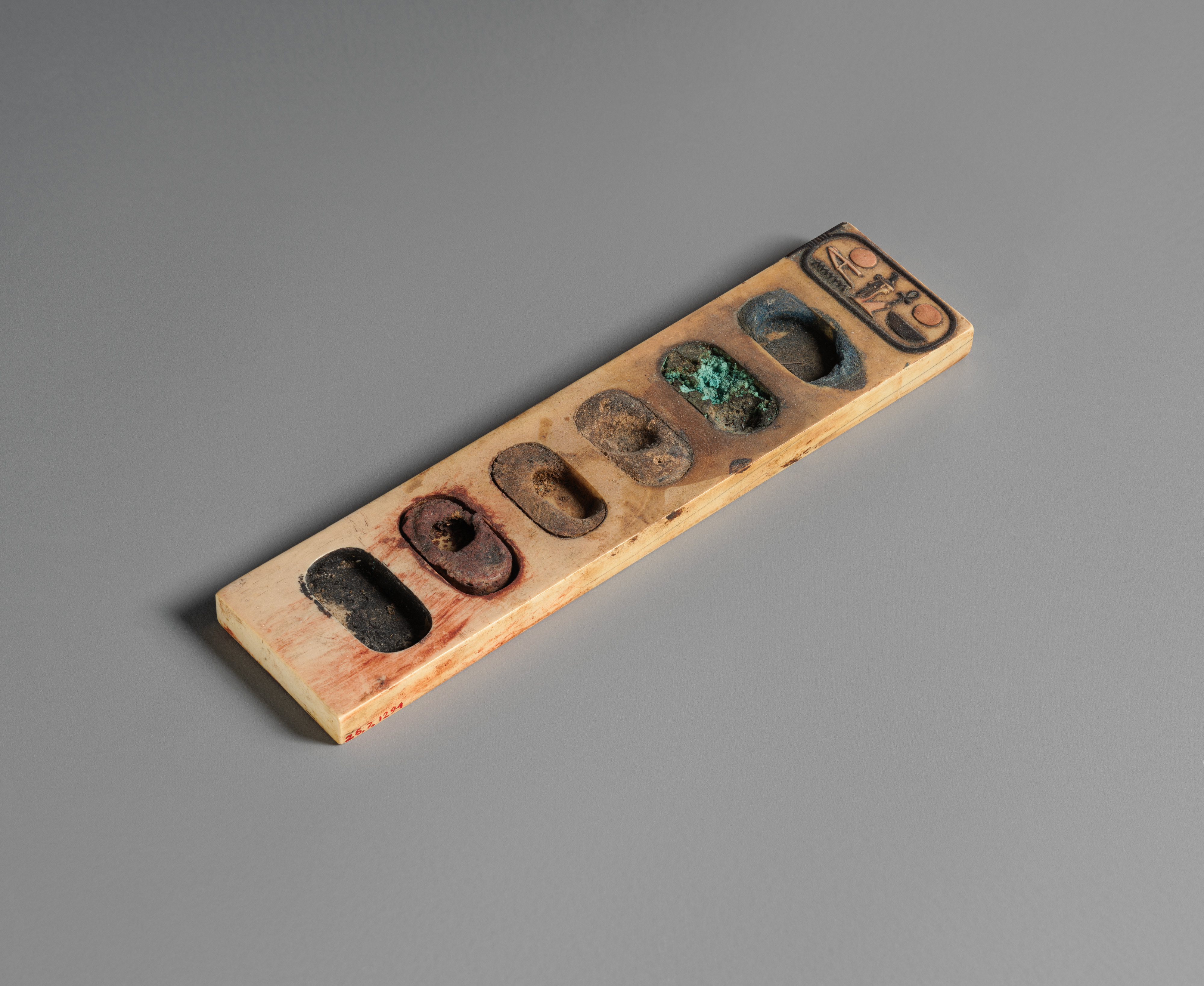 Ivory Egyptian painter's palette with oval wells containing colored pigments