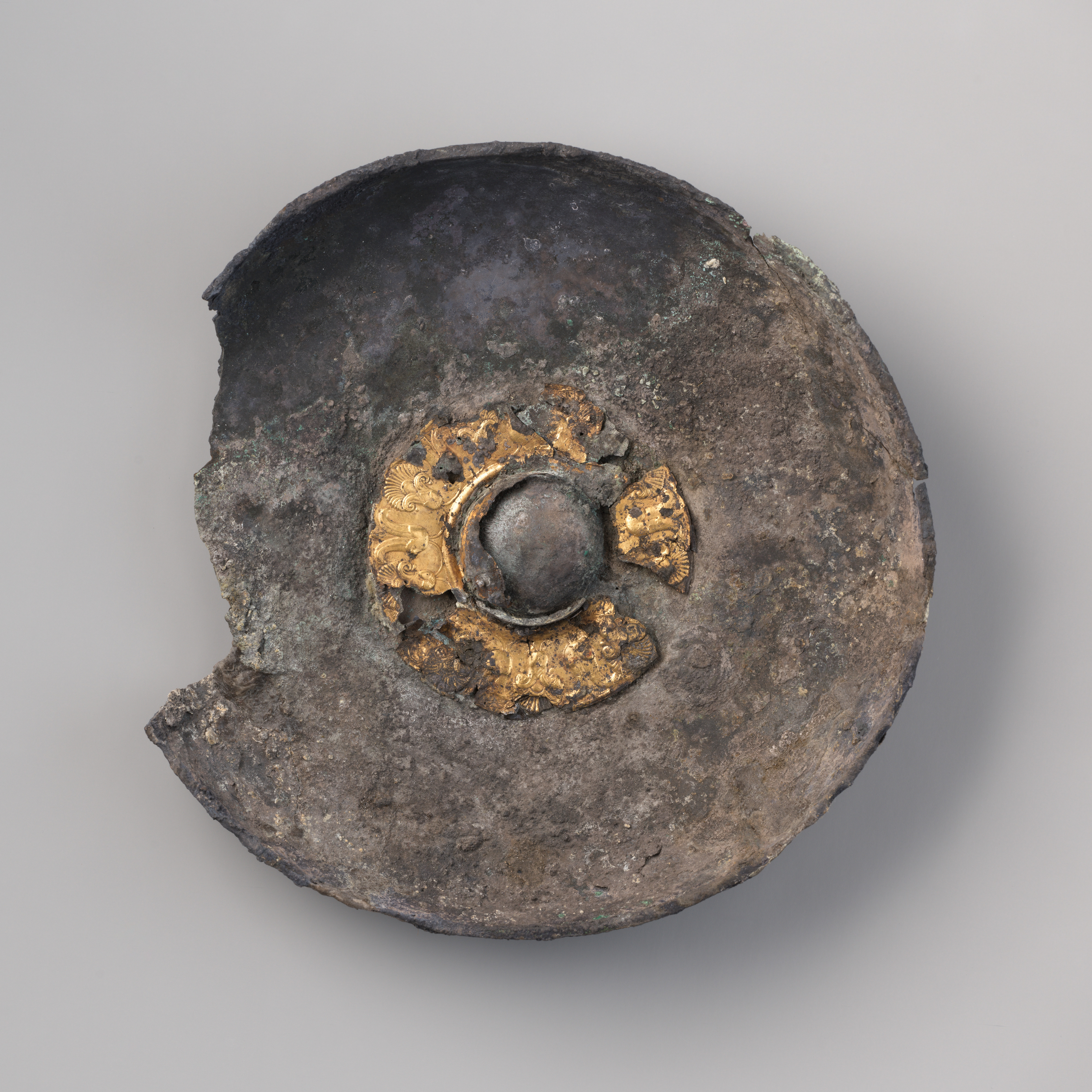 Shallow silver and gold libation bowl with a raised central boss and decorative band