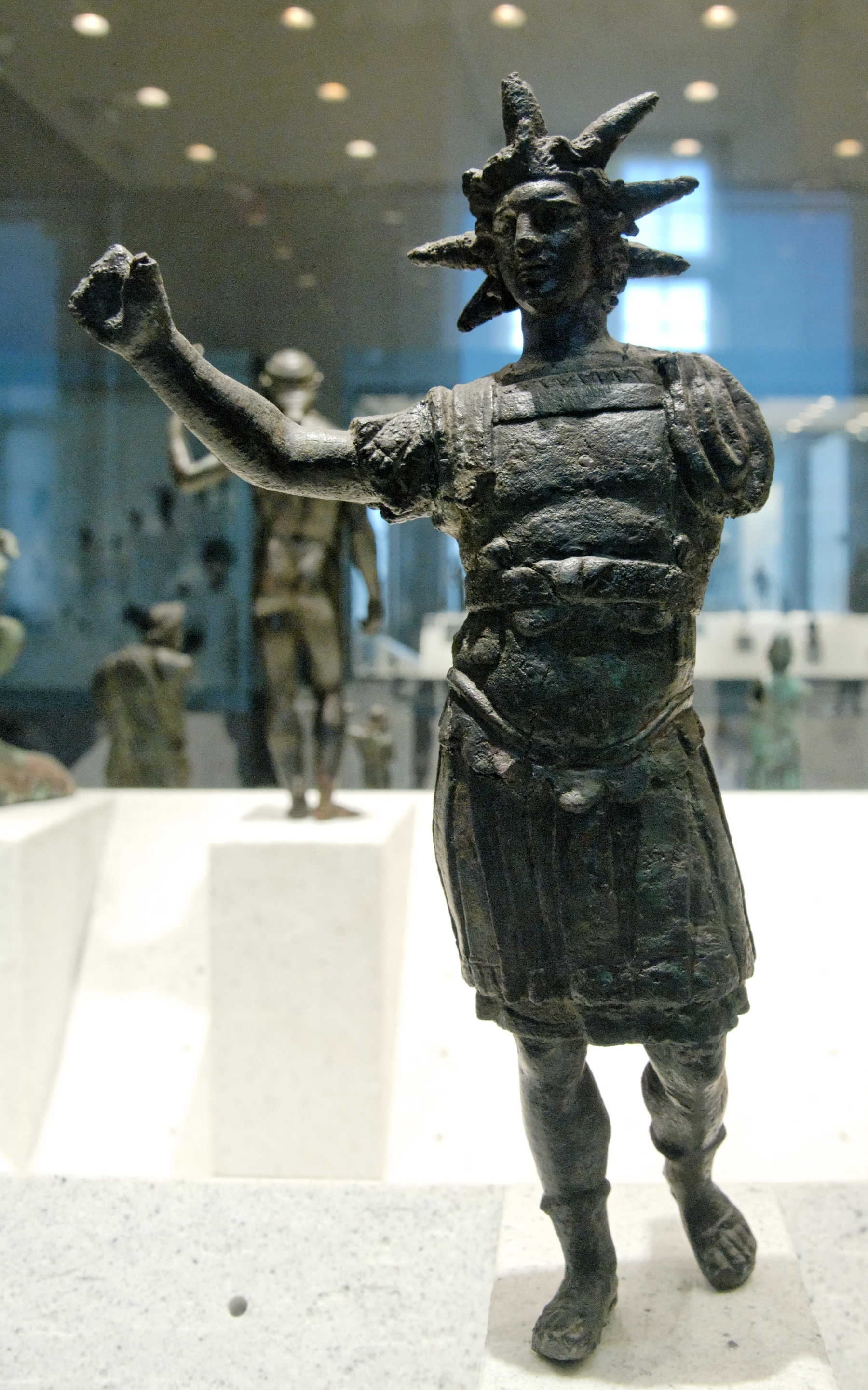 Bronze Helios wearing a breastplate and a crown with projecting solar rays.