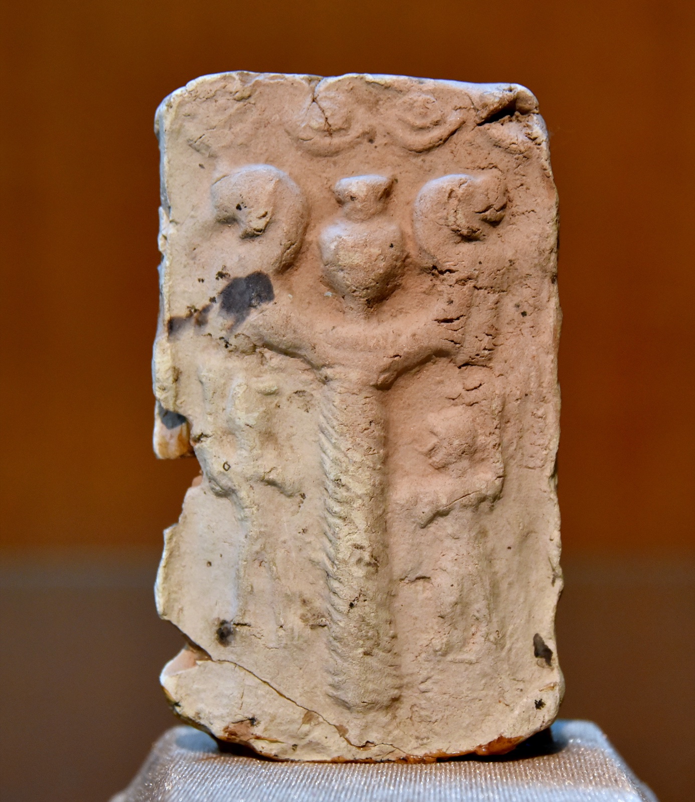 Nergal, Mesopotamian deity of the underworld, flanked by two small human figures