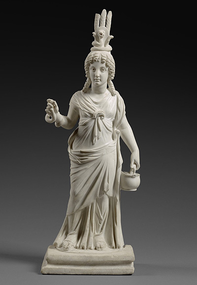 A marble statuette of a Goddess with a tall crown, holding a vessel