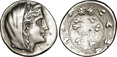 A silver coin with the veiled head of Demeter, a wreath on the reverse