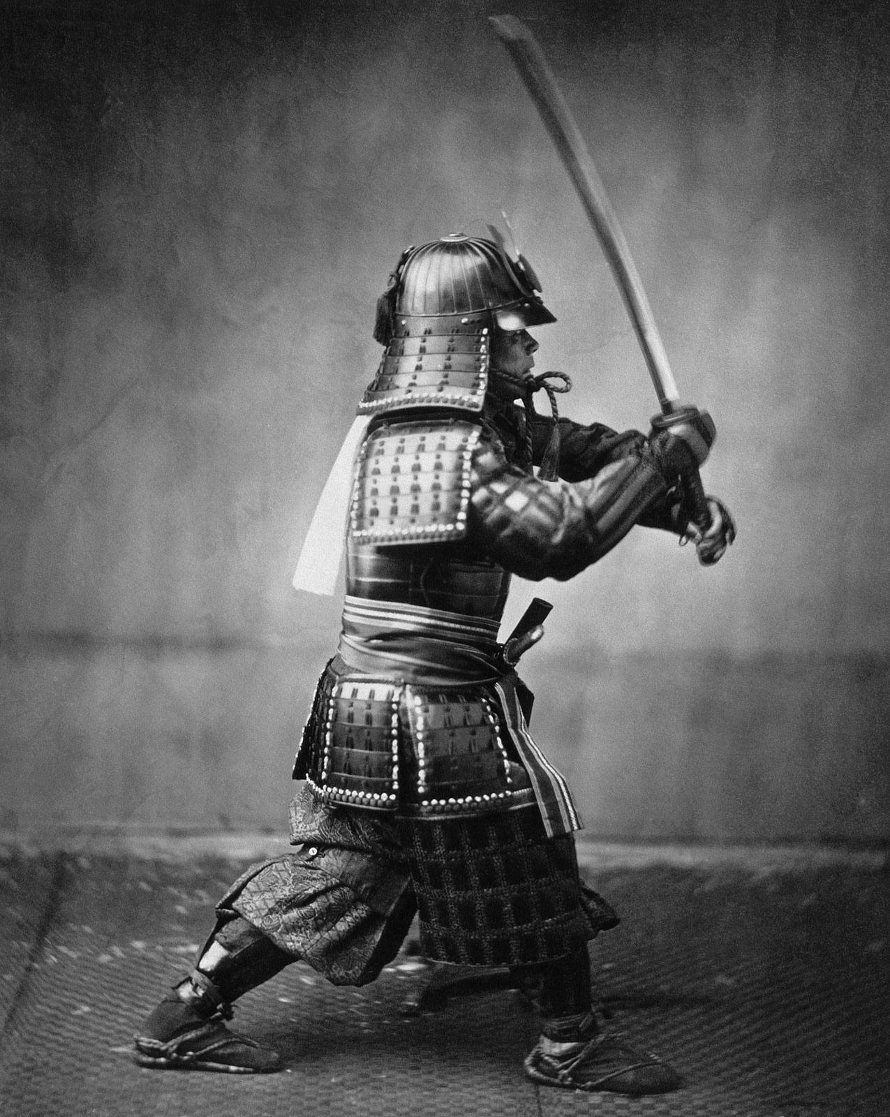 Samurai with sword,
        hand-coloured 
        photograph, 19th century