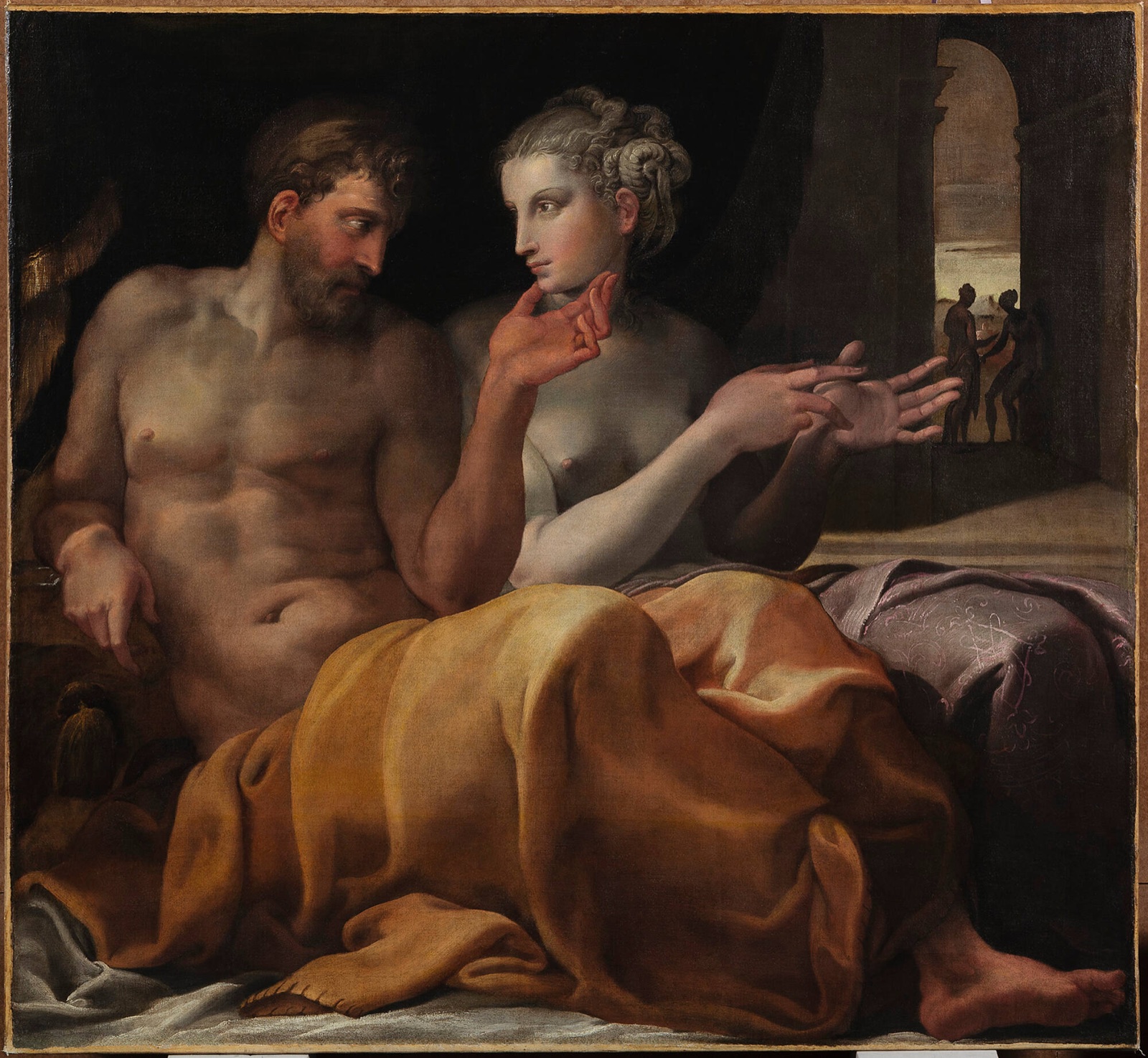Odysseus and Penelope seated together on a bed in a lamplit chamber, talking, with figures visible in the room behind them.