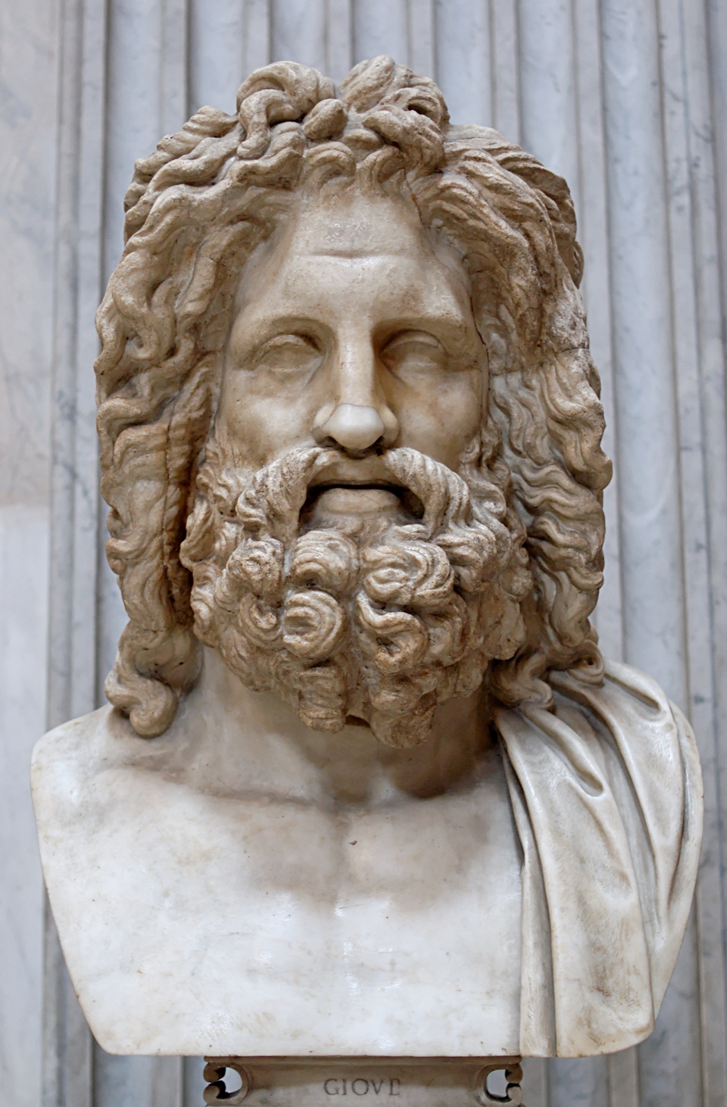 A colossal marble bust of Zeus with deep-set eyes, a high mane of hair and a full curling beard.