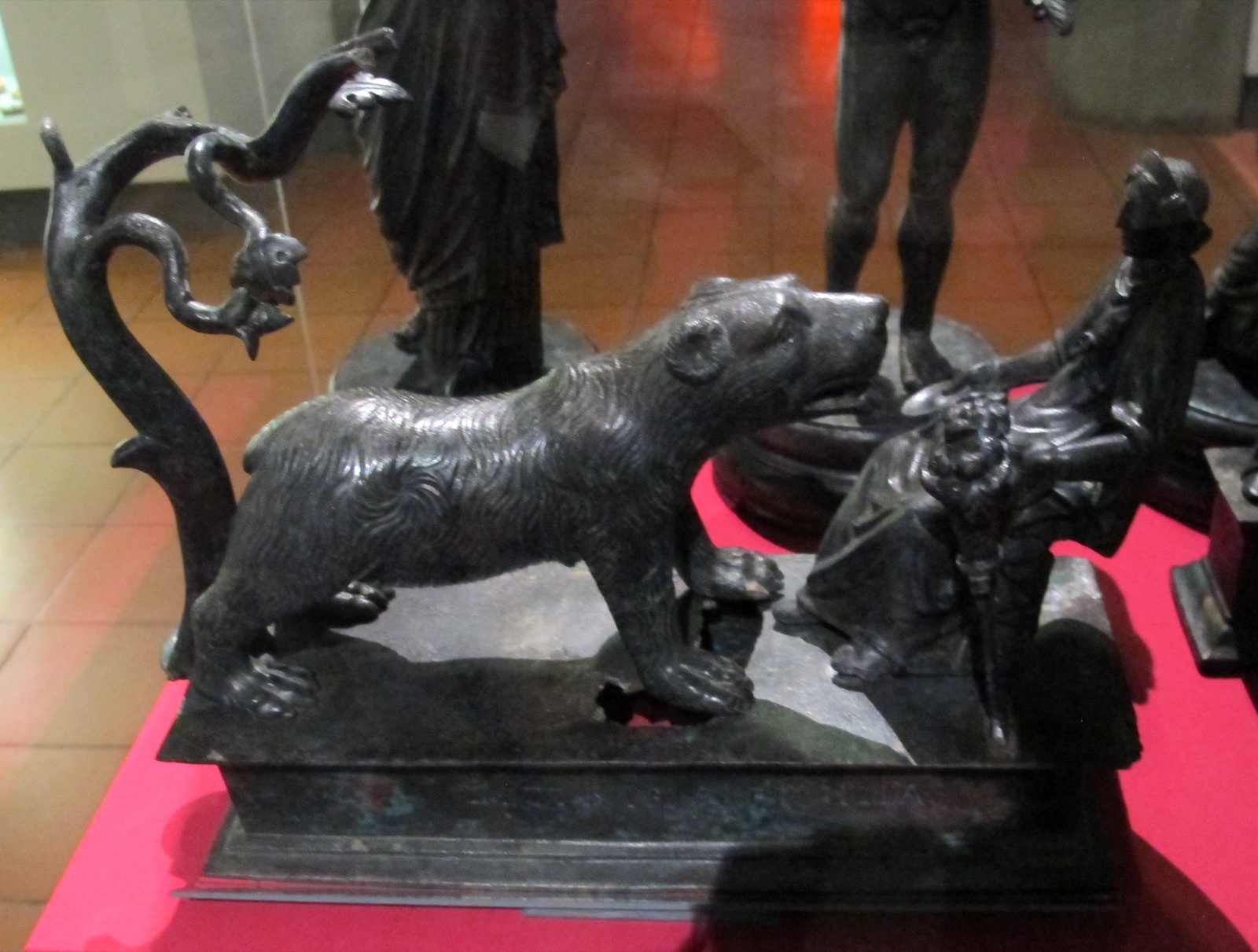 Bronze group of the goddess Artio seated facing a large bear, with a small tree behind the bear.