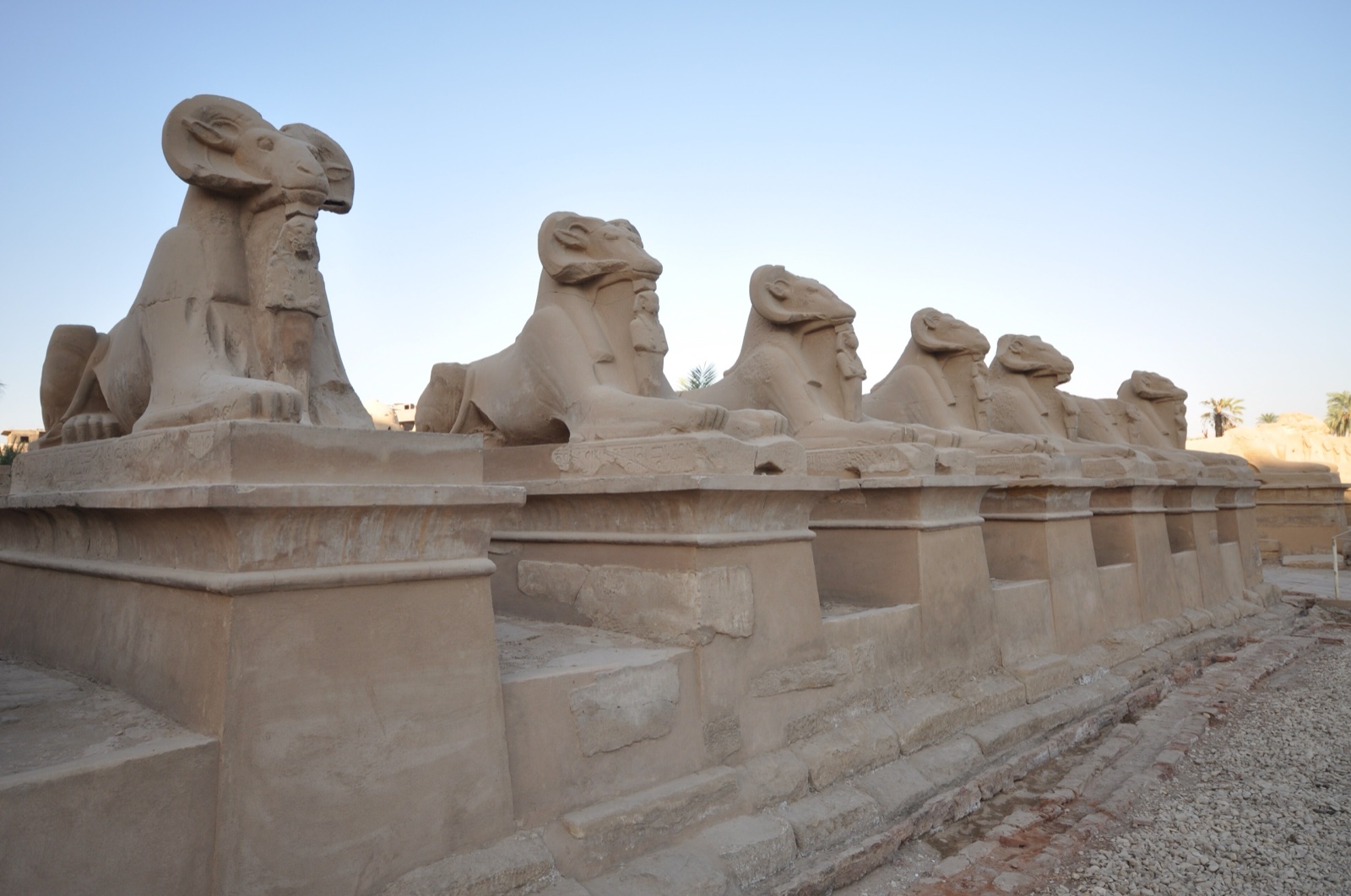 A row of ram-headed sphinxes lining the avenue to the first pylon of the Karnak temple complex.