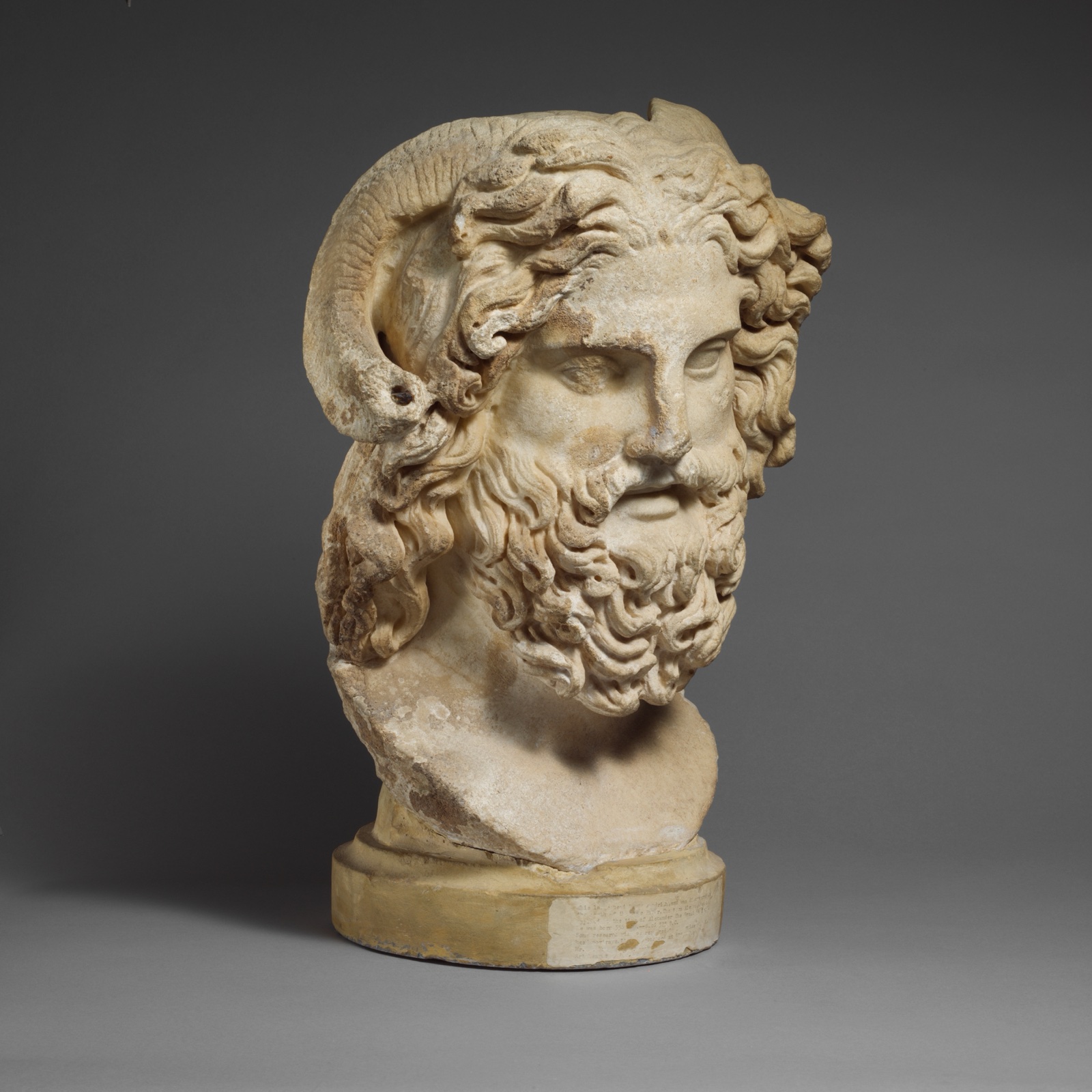 Marble head of a bearded Zeus with ram's horns.