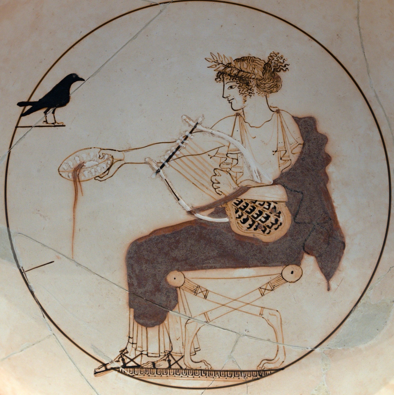 Painted cup interior: Apollo seated, wreathed, holding a lyre and pouring from a bowl, facing a black bird.